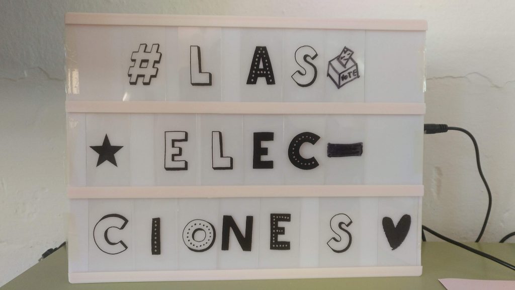 Caja lumínica con letras que pone: "Las elecciones"