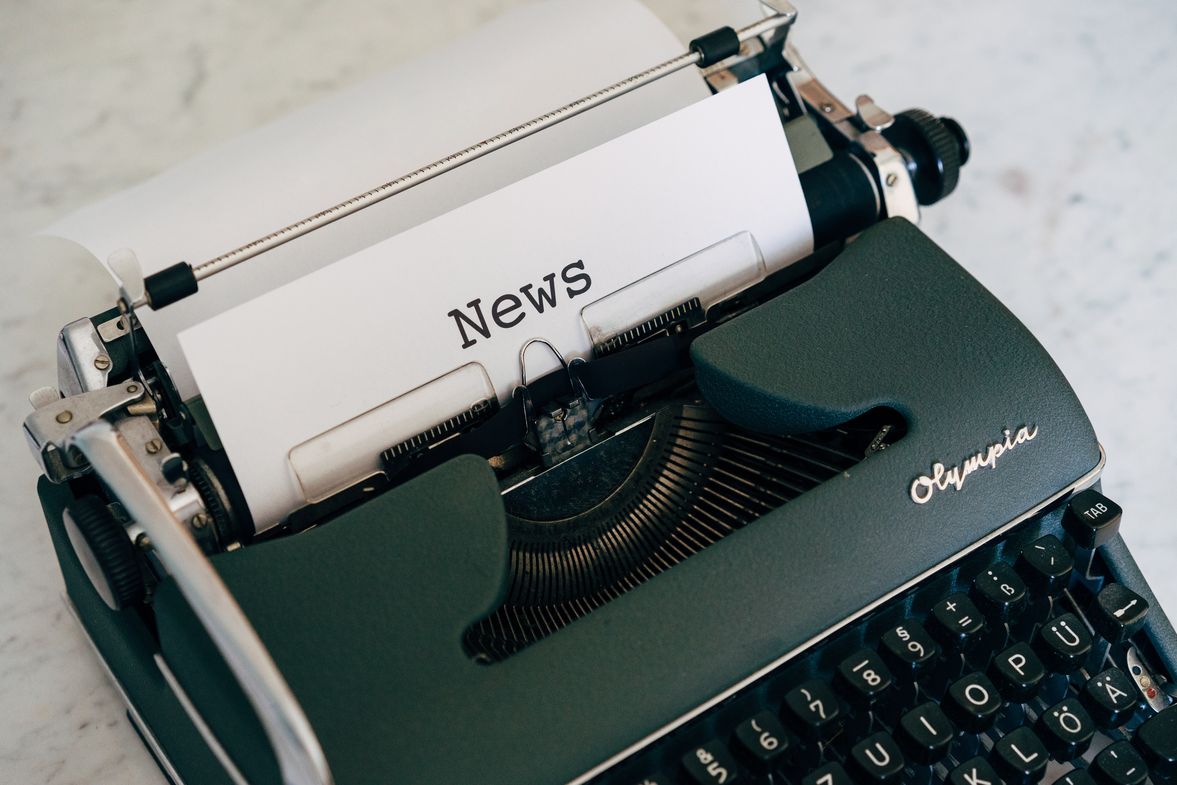 Imagen de maquina de escribir con folio que tiene de título "noticia"