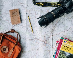 Objetos de viaje como cámara, mochila y mapas
