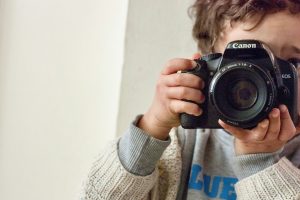 Niño haciendo foto con una cámara réflex