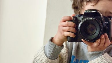 Niño haciendo foto con una cámara réflex