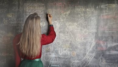 Maestra escribiendo en una pizarra