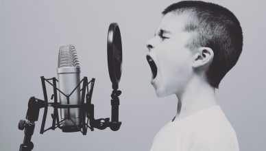 Niño gritando en micrófono de estudio de grabación