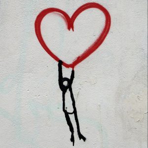 Grafiti de corazón con monigote colgando