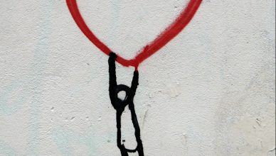 Grafiti de corazón con monigote colgando