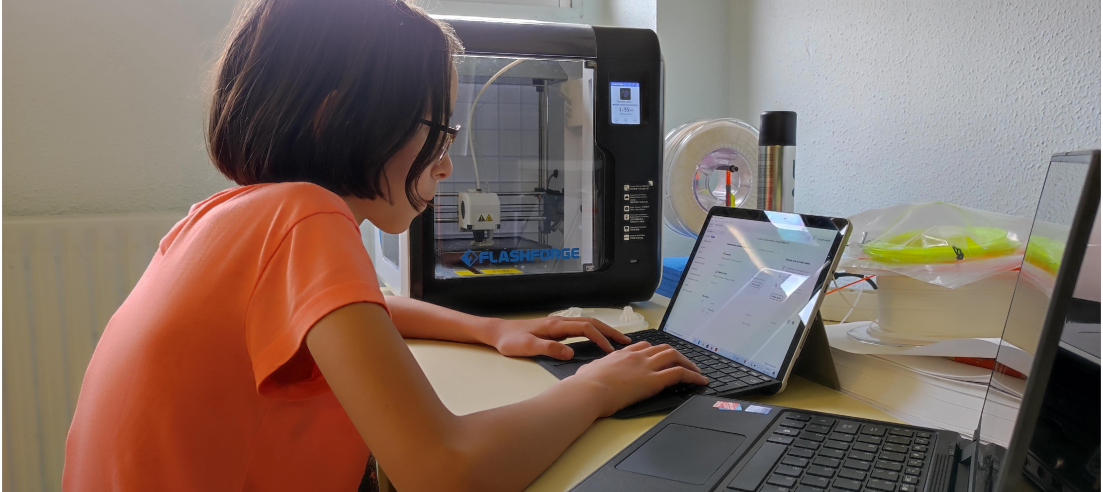 Alumna con ordenador e impresora 3D