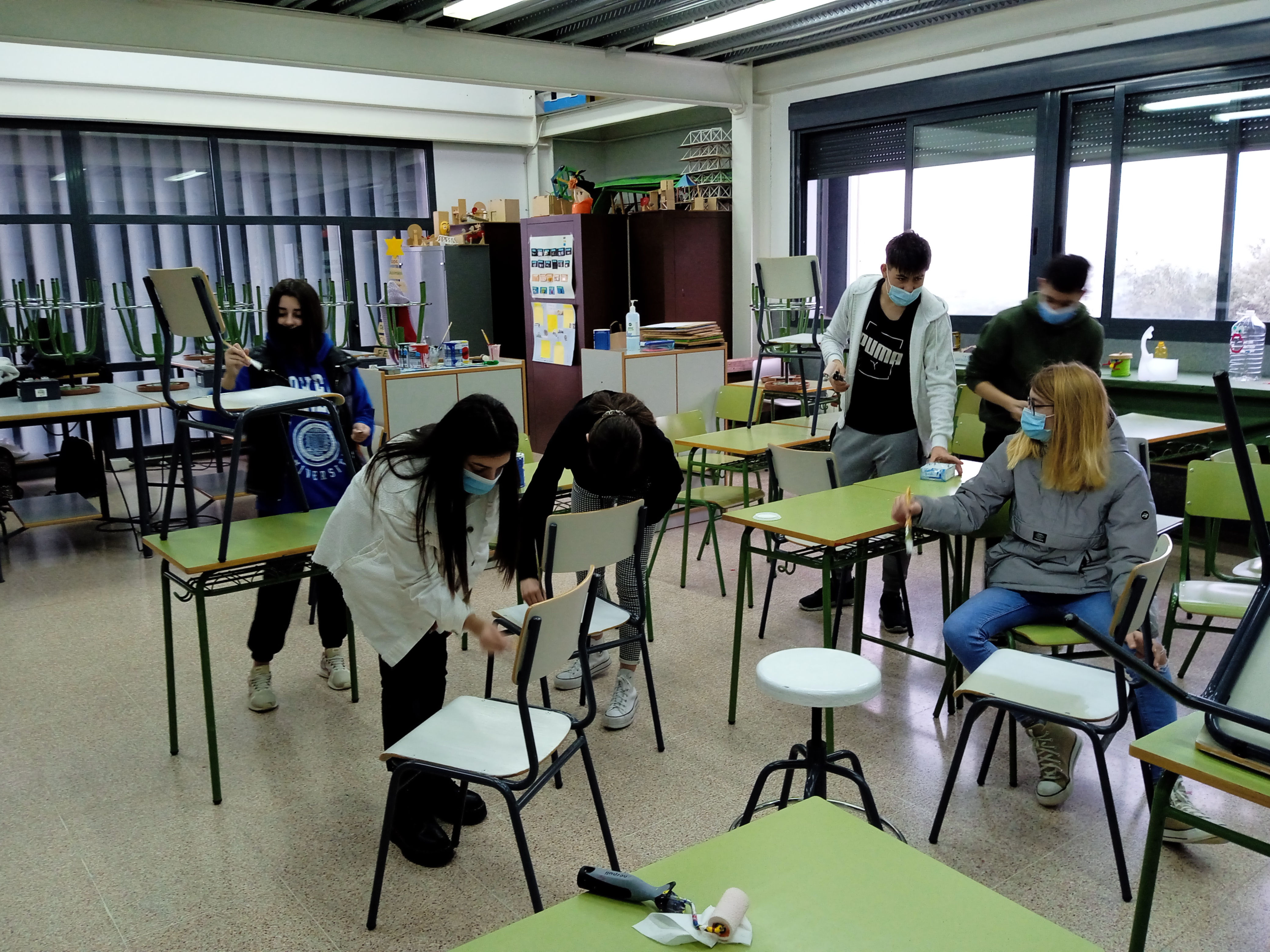 Estudiantes pintando sillas y taburetes del AdF