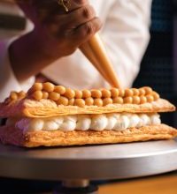 mano de pastelero poniendo adorno a pastel