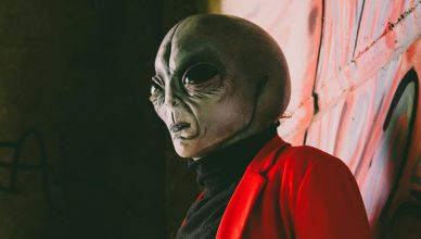Alien en pared roja con chaqueta roja